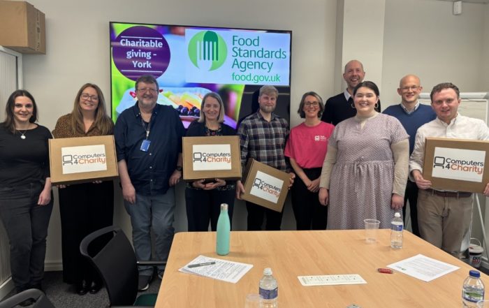 Several people holding carboard boxes with ‘Computers 4 Chairty’ written across the front, for “Tech That Makes a Difference: FSA’s Laptop Donation to Kyra”