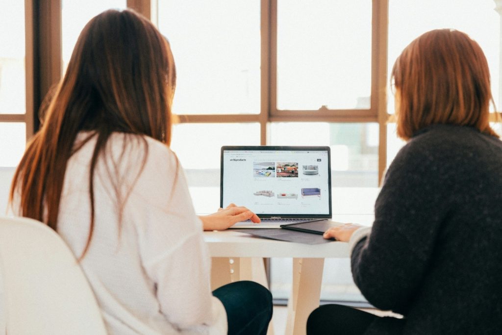 Interior, two women working on a laptop together in an office, for “Digital Confidence Starts Here: ICT with Anita”