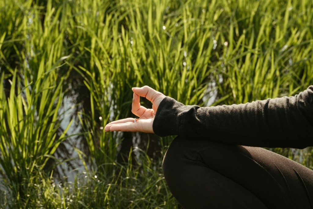 A women meditating in a grassy field, for “Marking the End of Our Capacitar Sessions at Kyra”