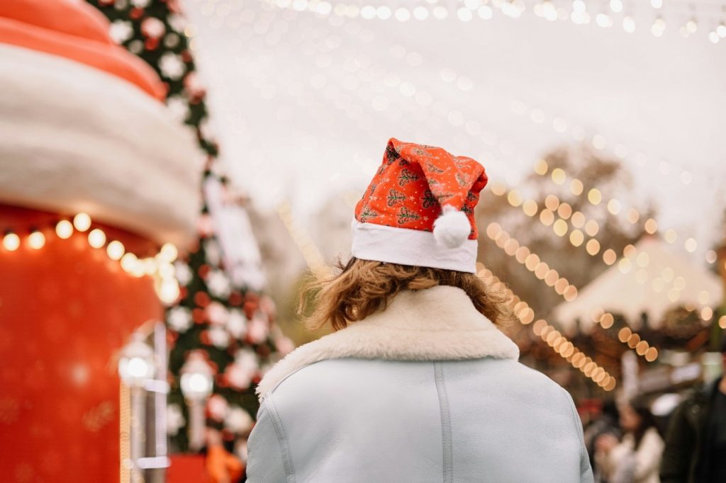 Exterior, a woman wearing a Santa hat in a Christmas grotto, for “Celebrating Together at Kyra’s Members’ Christmas Party”