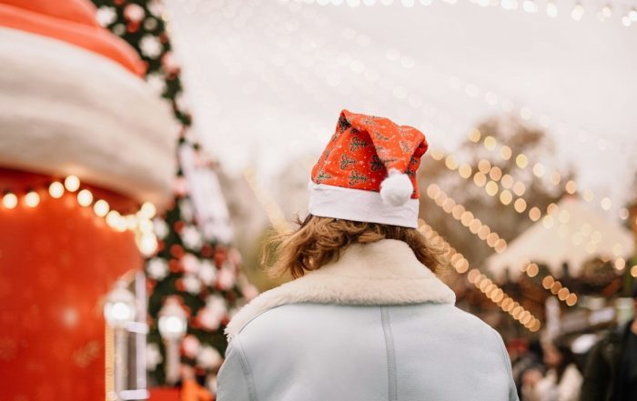 Exterior, a woman wearing a Santa hat in a Christmas grotto, for “Celebrating Together at Kyra’s Members’ Christmas Party”