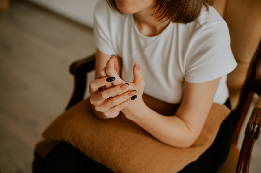 Interior, a woman sat in an armchair clasping her hands, for “Meet Ashley: From Member to Trustee”